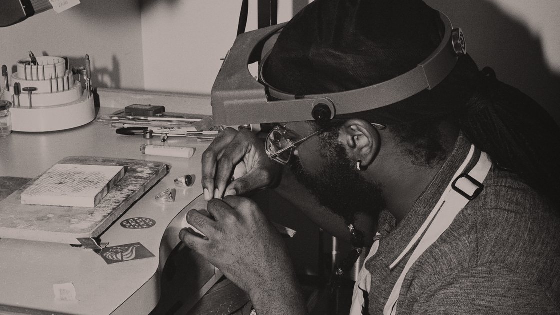 A BVLA apprentice at the bench, working under a magnifier