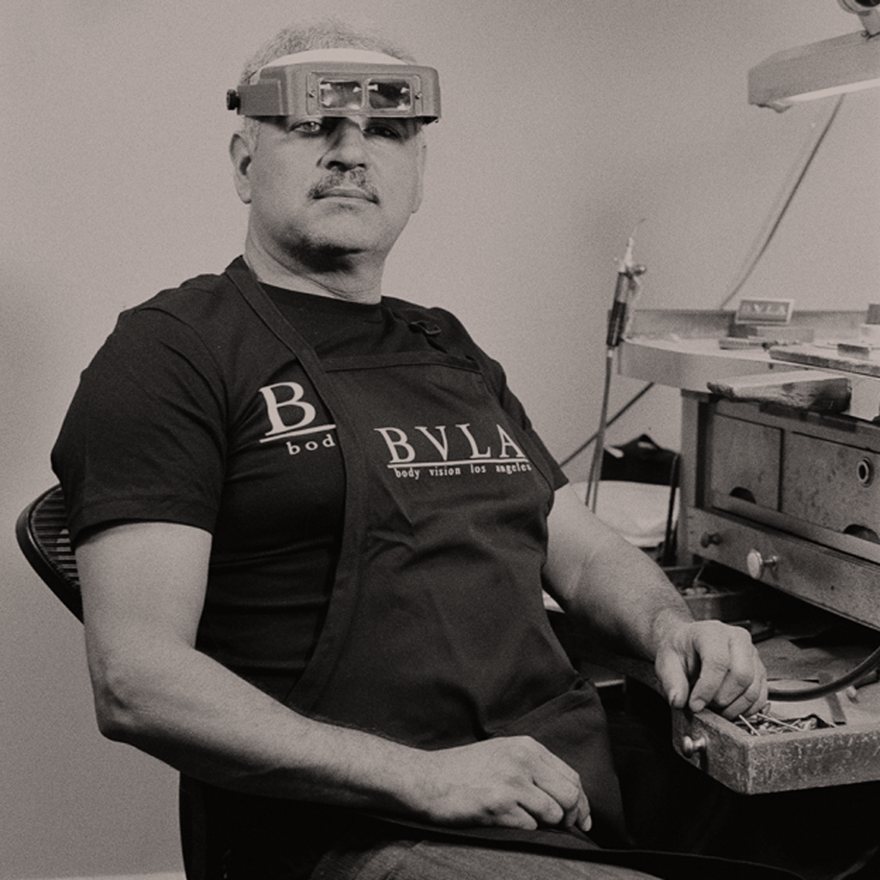 A BVLA bench jeweller in a head magnifier at his bench