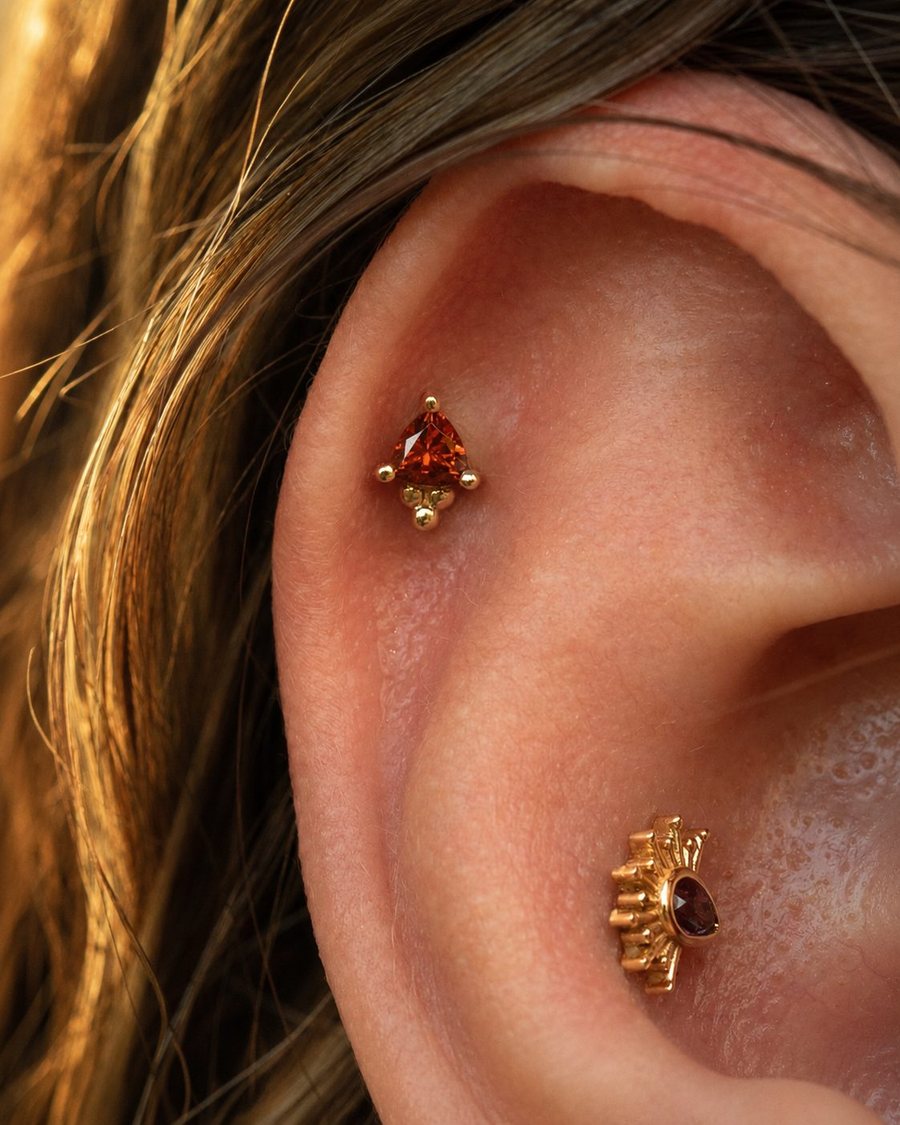 A gold piece held to an ear at the mirror, at the table at Platinum Point
