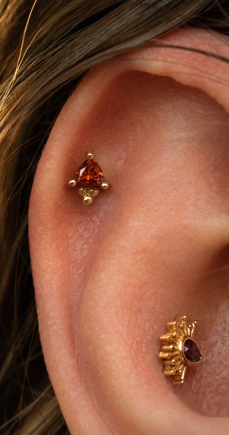 A Tiny Borderline in yellow gold worn in a conch, with a second piece above it