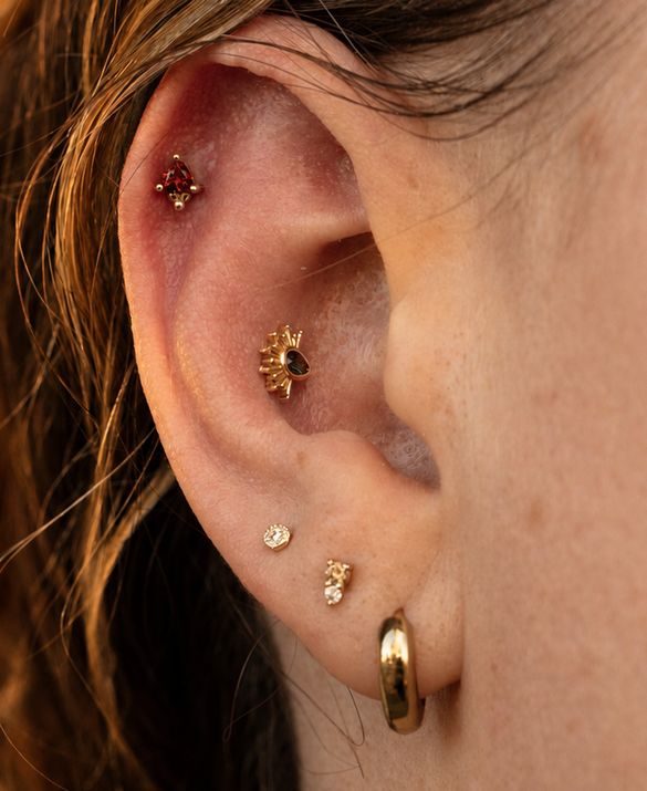 A fresh piercing, small and neat, in a lobe and up the ear